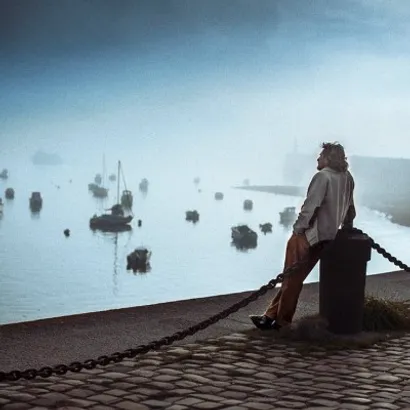 Pensive man looking at the fog in a small harbour